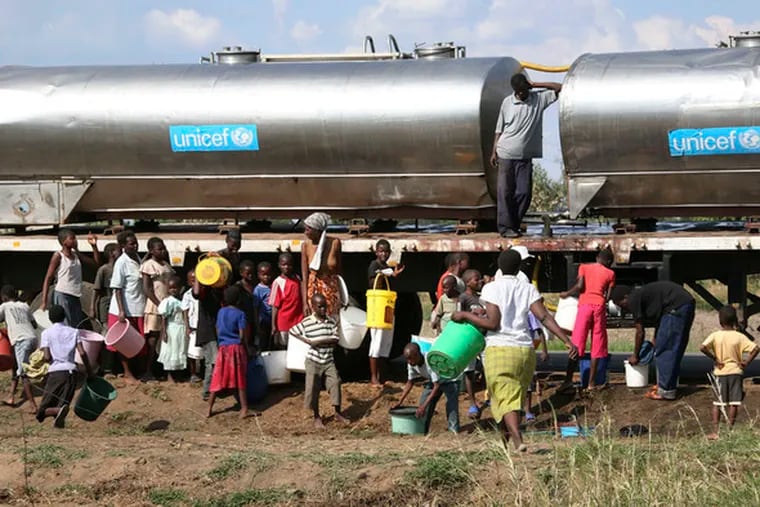 Women and children collect clean water from a UNICEF truck in Harare, Zimbabwe. With the United Nations reporting that the country&#0039;s cholera death toll has risen to 565, a group of doctors and nurses marched in the capital, only to be stormed by riot police.