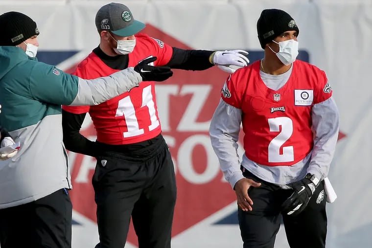 Eagles passing game coordinator Press Taylor (far left) chats with quarterbacks Carson Wentz (11) and Jalen Hurts (2) at practice this week.