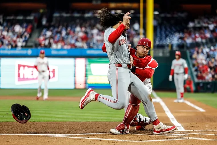 Phillies catcher J.T. Realmuto tags out the Reds’ Jonathan India at home for a double play to end the first inning on Monday.