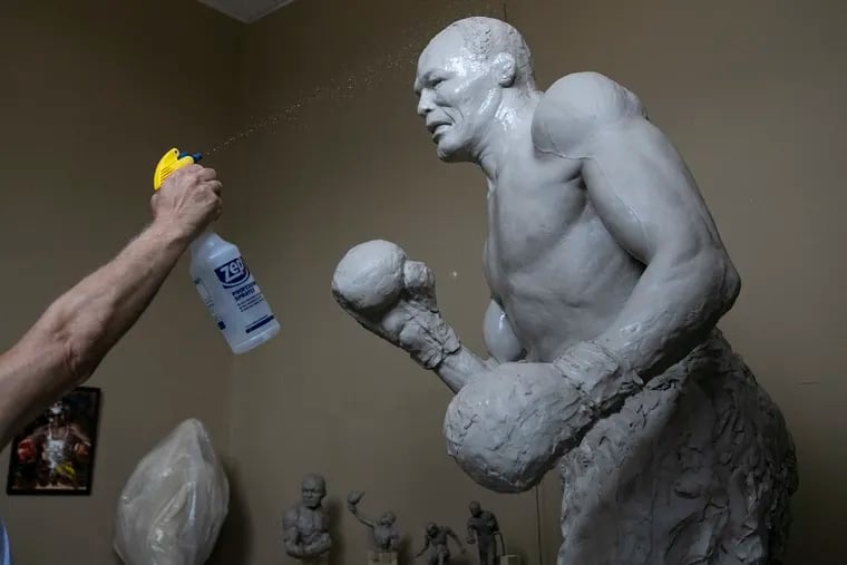 Carl LeVotch, artist of the sculpture of famous local boxer Jersey Joe Walcott, sprays the sculpture in progress at his studio in Pennsauken, NJ on Friday, July 17, 2020. The statue will be displayed on the Camden waterfront.