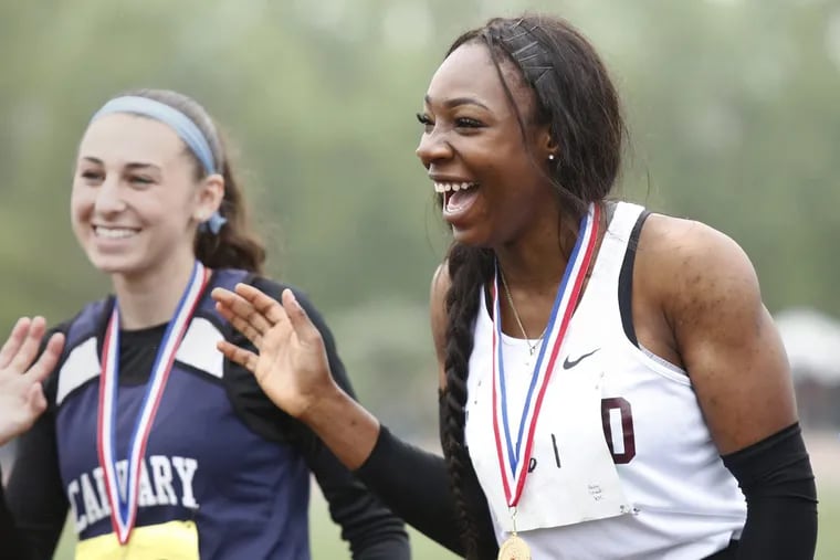 Girard College junior sprinting start Thelma Davies (right) waves after winning the Class 2A 100-meter race at the District 1 championships on May 19. Davies had to overcome self-consciousness over the rash that covered her arms and legs. Calvary Christian’s Alexandra Brizzi (left) finished second.
