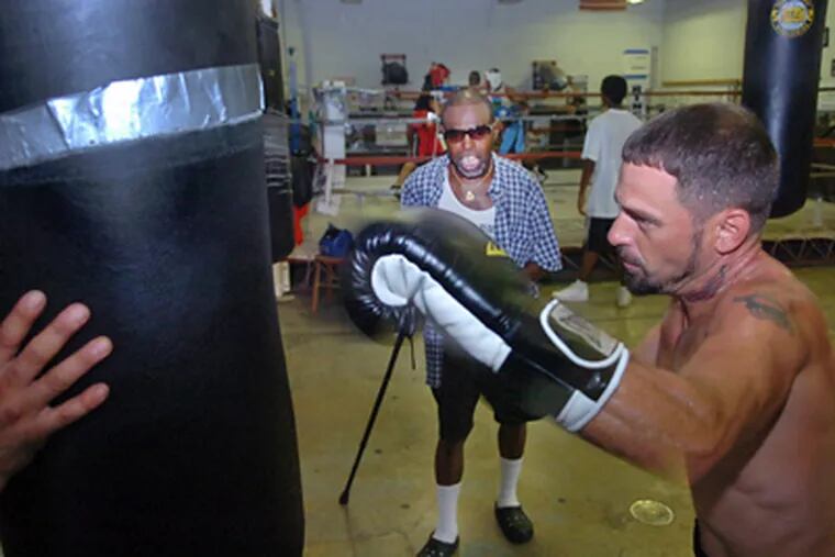 Former champ Lockridge in Camden gym giving tips to Bobby Toney. (Sarah J. Glover / Staff Photographer)