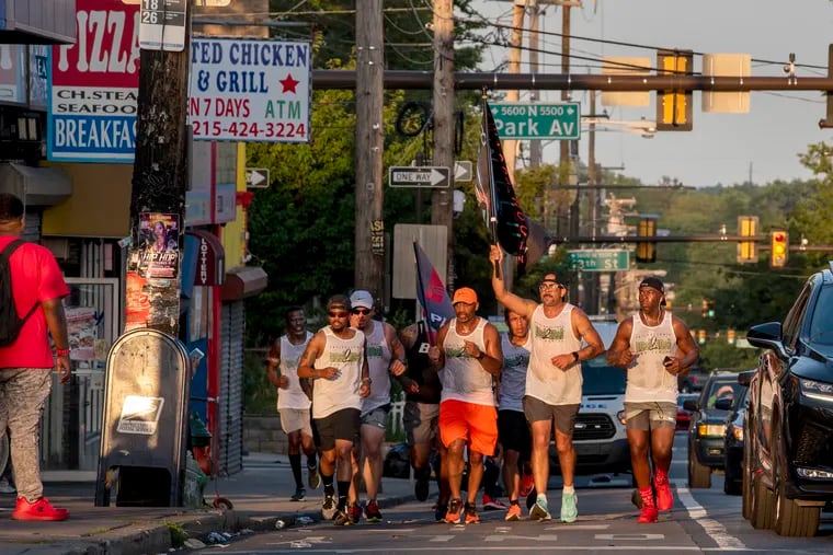 Runners take to the streets in North Philadelphia on Monday. The runners, who grew up and still live in Philly, have started a Hood 2 Hood running series to run through some of the toughest neighborhoods as a way to reach young people in need.