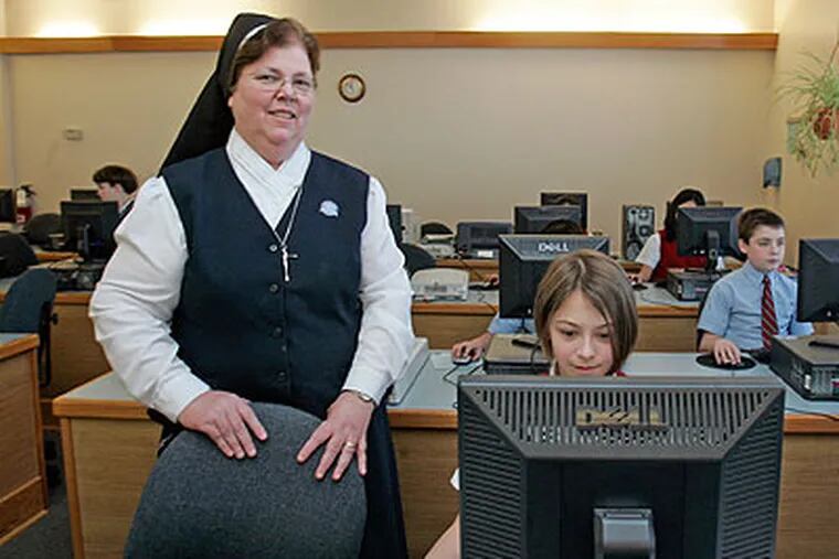 Sister Helen Thomas, Principal of Laurence Catholic School in Upper Darby, in the computer lab of the school next to 11-year-old Emma Barrara. (Bonnie Weller / Staff Photographer)