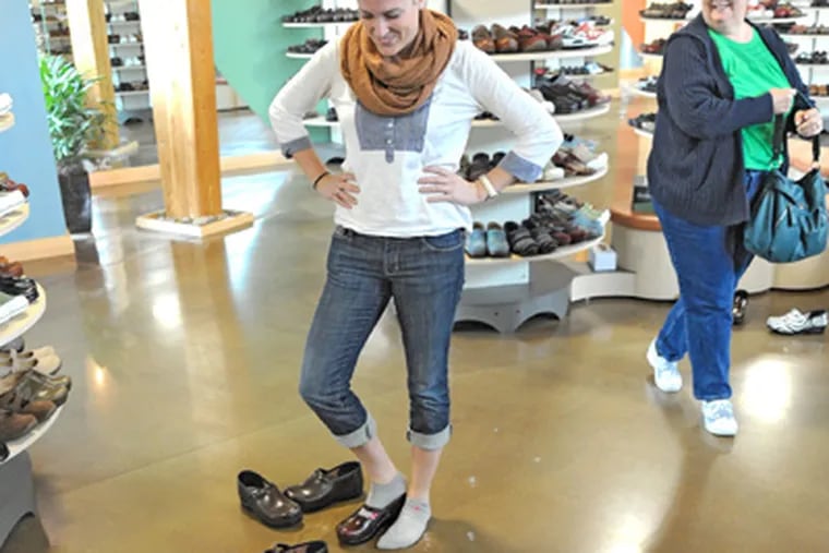 To find the right fit, Sarah Horstmann, a nurse from Washington, eyes an array of clogs at the Dansko outlet store. (Clem Murray / Staff Photographer)