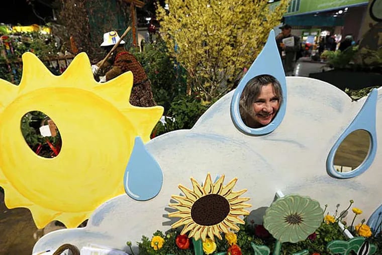 File photo: Sidney Hughes of Gloucester City peeks through a raindrop at the Camden Children's Garden exhibit, &quot;Fun With Art in a Children's Community Garden,&quot; at the Philadelphia Flower Show. (Yong Kim/Staff)
