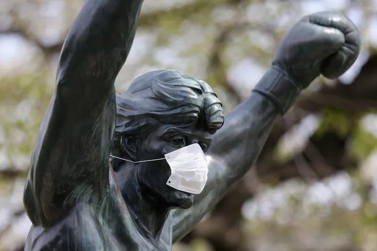 A mask covers the face of the Rocky statue in front of the Philadelphia Museum of Art on Friday, April 17, 2020. People are encouraged to wear masks or face coverings to reduce the spread of the coronavirus.