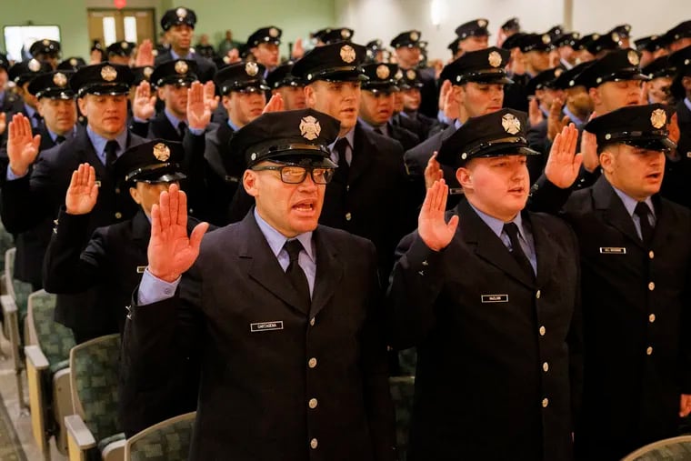 Marcelino Cartagena takes the oath of office alongside fellow fire department graduates.