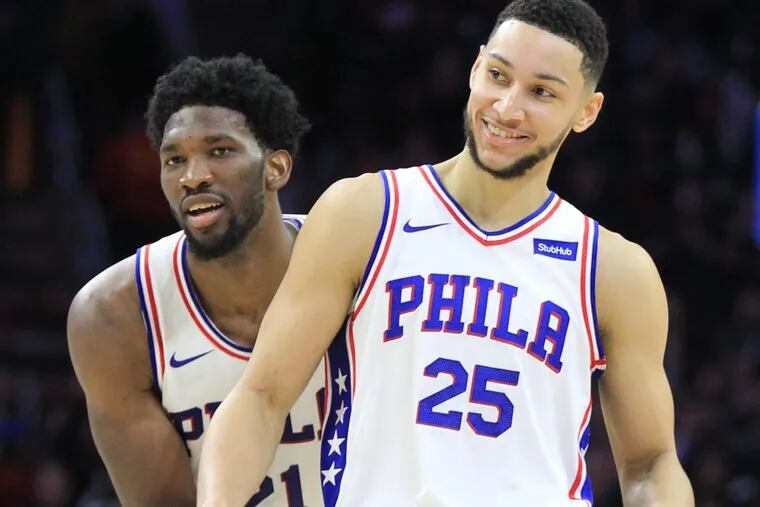 Joel Embiid, left, of the Sixers grabs Ben Simmons from behind as he celebrates a pass Simmons made to Dario Saric against the Pistons at the Wells Fargo Center on Dec. 2, 2017.