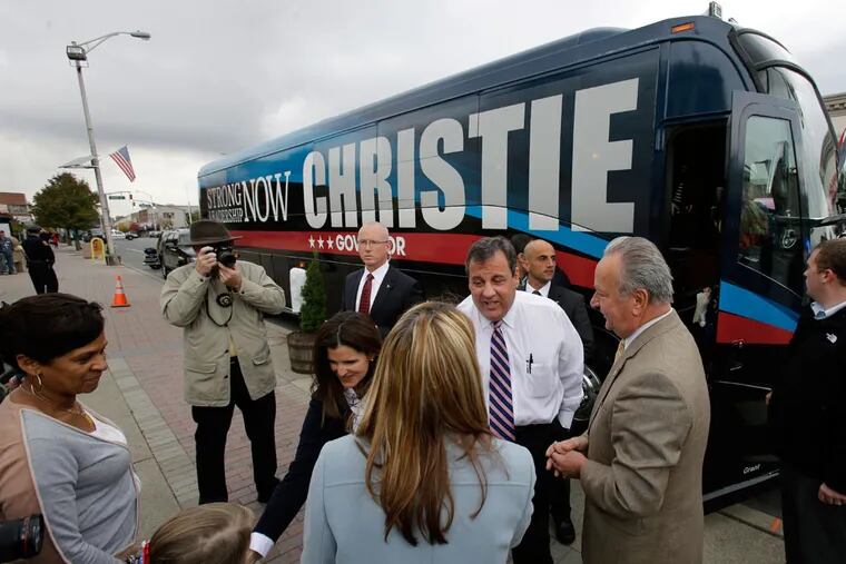 Gov. Christie greets well-wishers in Linden, including Mayor Richard J. Gerbounka (second from right), on a late-campaign bus trip. Polls suggest Christie will win reelection in a landslide over Democrat Barbara Buono on Tuesday.