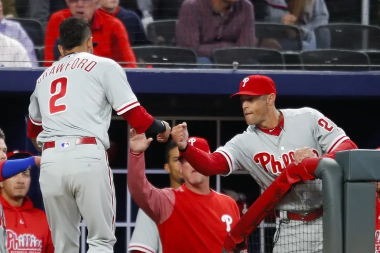 Philadelphia Phillies J.P. Crawford (2) celebrates with manager Gabe Kapler after scoring in the third inning of a baseball game against the Atlanta Braves, Friday, March 30, 2018, in Atlanta. (AP Photo/Todd Kirkland)