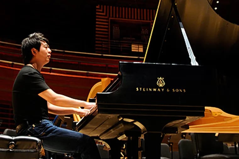 Lang Lang tries out a piano on stage in Verizon Hall, where he will play three concerts this week with the Philadelphia Orchestra. “I know what I’m trying to achieve in art, so there are no worries,” he says.  (Tom Gralish / Staff Photographer)