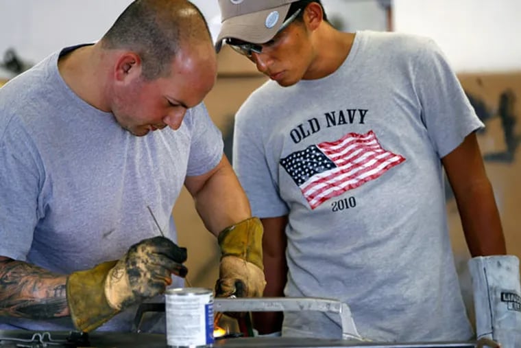 Joe Blubello (left) gives Gilberto "Chango" Guerra, 22, some welding tips during a tutorial at Car Cure in West Chester. Guerra, who has basic welding skills in Honduras, is learning more advanced techniques while visiting in the area. September 18, 2014. ( MICHAEL S. WIRTZ / Staff Photographer )