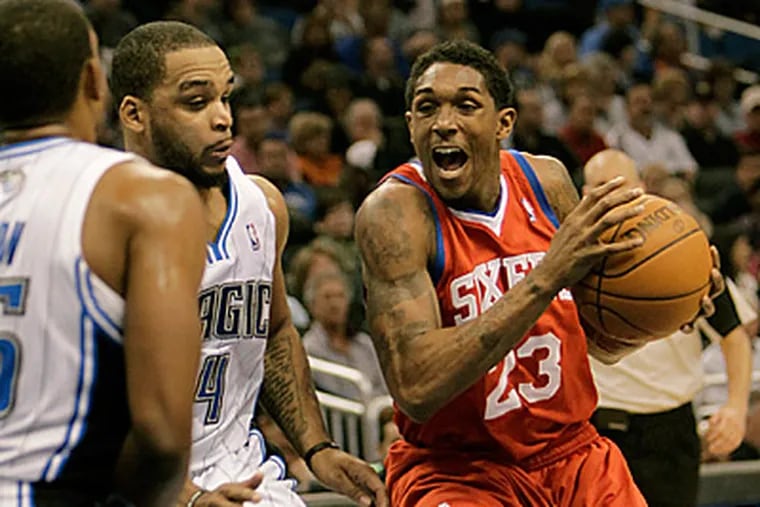 Lou Williams, right, drives past Orlando Magic's Chris Duhon, left, and Jameer Nelson during the first half. (AP Photo/John Raoux)