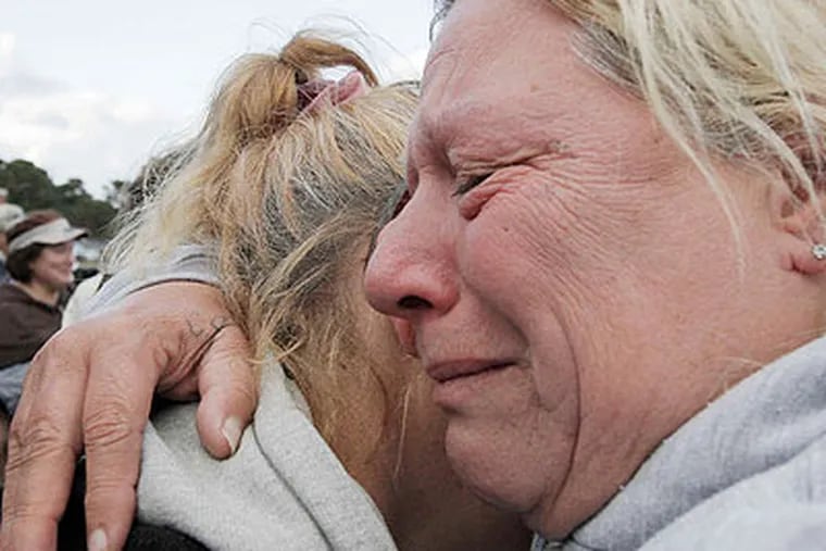 Kelly Borden (left) and in-law Bonnie Miller embrace at the FEMA center. (Elizabeth Robertson / Staff Photographer)