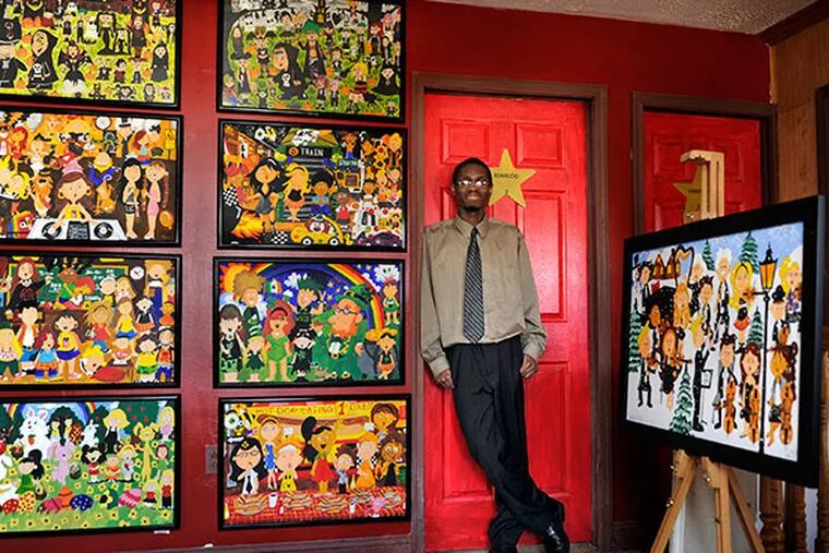 Autistic artist Ronaldo Byrd  with just some of his artwork, displayed at the Burlington house he shares with his mother. ( TOM GRALISH / Staff Photographer )