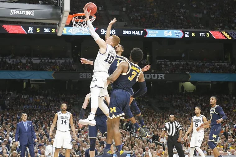 Donte DiVincenzo goes in for a layup past Michigan guards Zavier Simpson and Charles Matthews in the NCAA championship game. Villanova beat the Wolverines, 79-62, for its second national championship in three years.