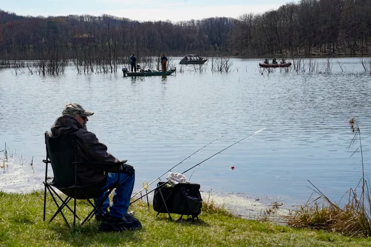 Anglers fish from the shore and from boats at Glade Run Lake Conservancy, on opening day of trout fishing season in Pennsylvania, Saturday, April 3, 2021, in Valencia, Pa.