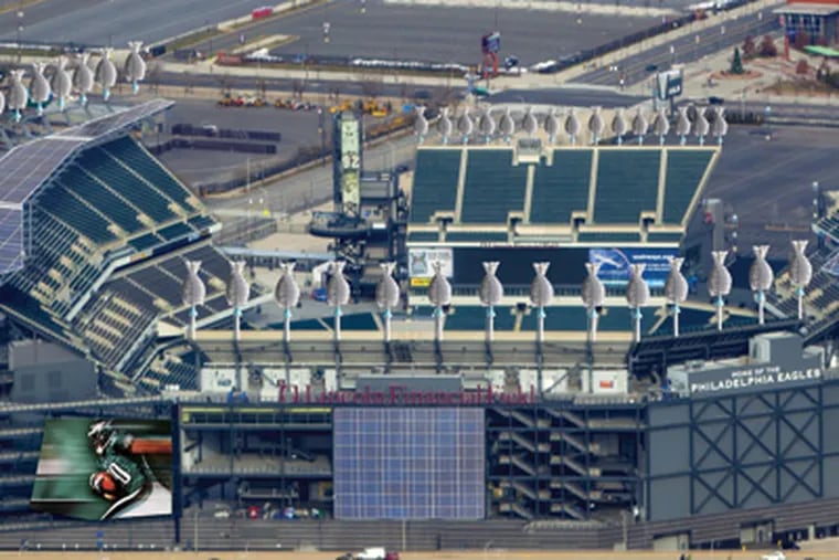 An artist’s rending of Lincoln Financial Field with the addition of wind turbines around the upper edge and solar panels covering portions of the stadium roof and facade, expected to be installed by September.