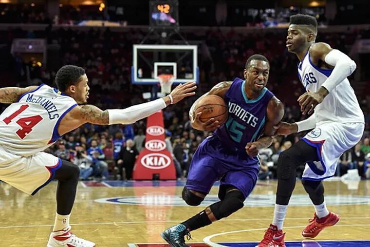 Charlotte Hornets guard Kemba Walker (15) drives to the net as Philadelphia 76ers forward Nerlens Noel (4) and 76ers guard K.J. McDaniels (14) defend during the second quarter of the game at Wells Fargo Center. (John Geliebter/USA TODAY Sports)