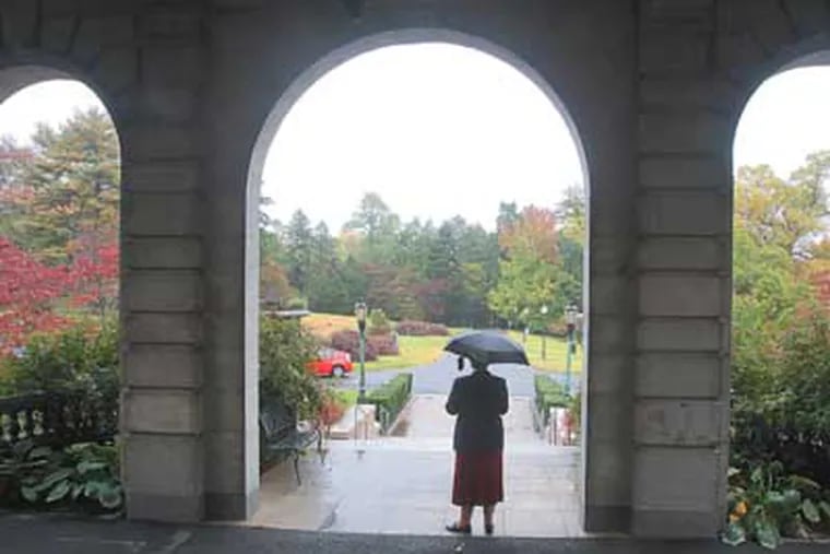 Sister Anne Lythgoe stands in the arches on the front side of Elstowe Manor on the Elkins Estate. ( Charles Fox / Staff Photographer )