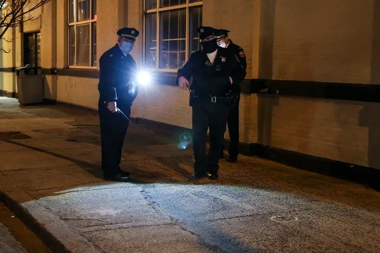 Philadelphia police look over a crime scene where a 25-year-old man walking a dog was fatally shot in the chest at 31st and Jefferson Streets on Wednesday.