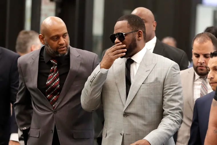 Musician R. Kelly, right, arrives at the Leighton Criminal Court building for an arraignment on new sex-related felonies Thursday, June 6, 2019, in Chicago. Thursday's hearing comes a week after prosecutors announced the new counts, including four of aggravated criminal sexual assault. (AP Photo/Charles Rex Arbogast)