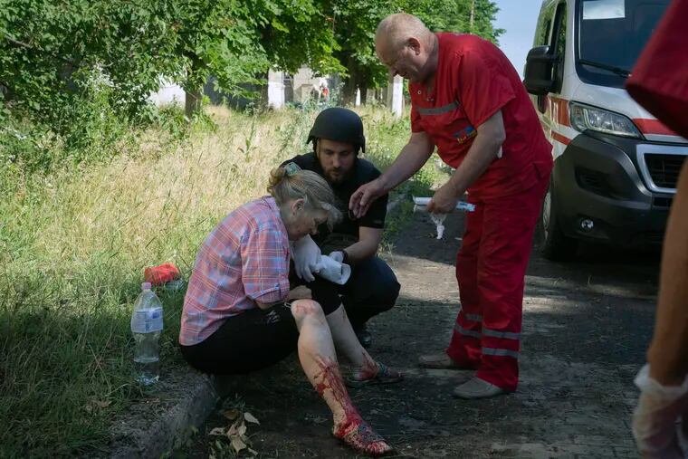 A police officer and paramedic give first aid to a woman wounded by the Russian shelling in Slavyansk, Donetsk region, Ukraine, on Monday.