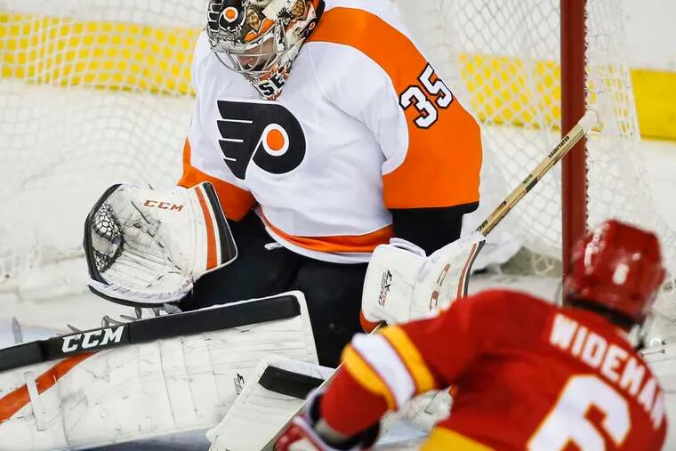 Flyers goalie Steve Mason is beaten by Calgary's Dennis Wideman at the 16:15 mark of the second period. Mason gave up a second goal less than two minutes later and was replaced by Ray Emery.