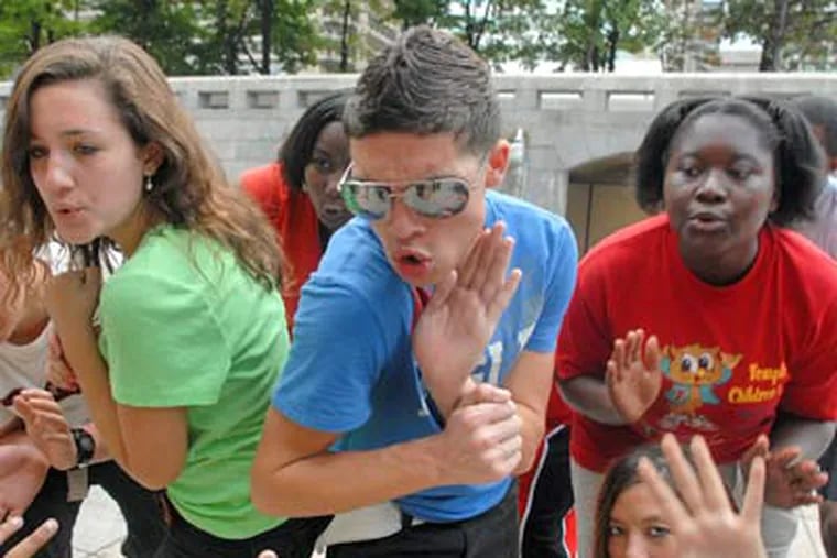 Teens rehearse "Flash!," a Philly Fringe show that channels a flash mob's energy into art. Actors include (from left) Emma Moreno, Daysha Gregory (rear), Demitre Rodriguez, Tanaisha Coleman and Hannah Poremba (bottom right). (Tom Gralish / Staff Photographer)