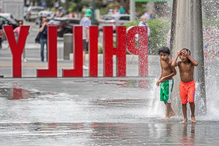 Alston Groomes, 7 left, and his brother, Miles Groomes, 6, right, cool off in the large fountain in Love Park as they and their family from Cherry Hill, NJ came over to Philadelphia to “fountain jump” to keep cool, on October 2, 2019.  Philadelphia recorded historic heat that day. Temperatures will continue to rise in the coming decades, environmental scientists predict.
