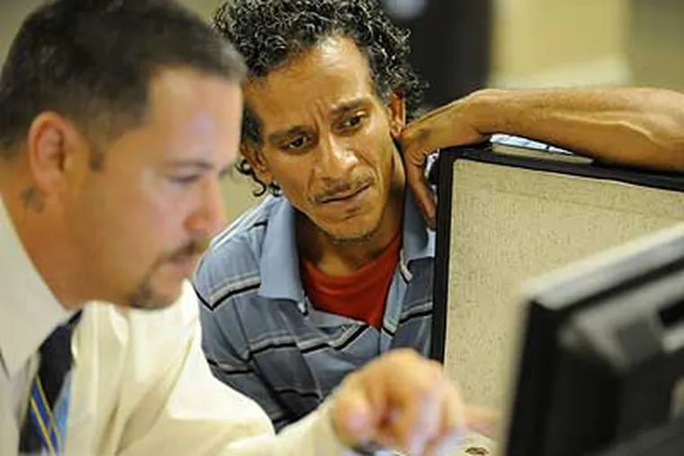 Martin Rosa, 43, looks on as George Ruiz, a certified recovery specialist, works to find Section 8 housing for Rosa. Rosa is originally from New York, but came to Philadelphia 1 1/2 years ago to "seek recovery." (Clem Murray / Staff Photographer)