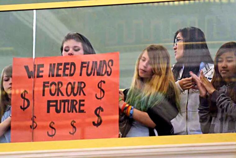Students in the balcony hold signs during Philadelphia school district budget hearings before City Council May 7, 2014. ( TOM GRALISH / Staff Photographer