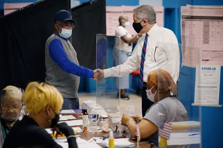 District Attorney Larry Krasner (right) shakes hands with a poll worker during a stop at William C. Longstreth School in Philadelphia's Kingsessing section on primary election day, Tuesday, May 18, 2021. Krasner and several others, including State Rep. Rick Krajewski and City Councilmember Jamie Gauthier, thanked poll workers at the polling place.