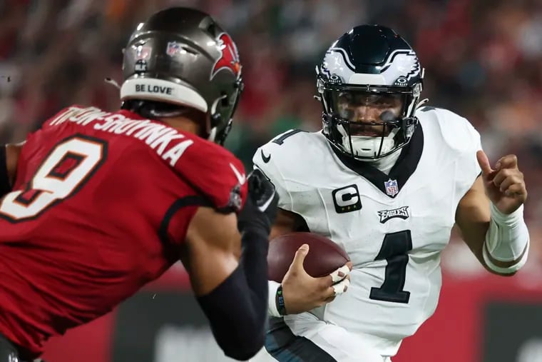 Eagles quarterback Jalen Hurts keeps the ball on a run with Tampa Bay Buccaneers linebacker Joe Tryon-Shoyinka giving chase in the wild-card round of the NFL playoffs at Raymond James Stadium in Tampa , Fla. on Monday, Jan. 15, 2024.