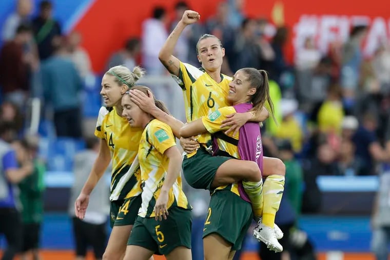 Australia's Chloe Logarzo (top) celebrates with teammates at the end of the game.