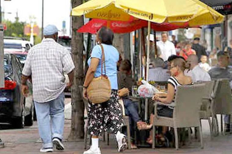 Pedestrians squeeze past tables set up outside Pizzicato at 3rd and Market. (David Maialetti / Staff Photographer)