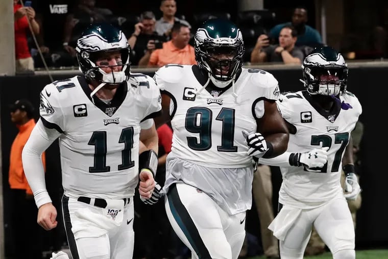 Fletcher Cox (91, running onto the field last season at Atlanta with Carson Wentz) knows he will have to assume part of the leadership burden formerly carried by Malcolm Jenkins (27).