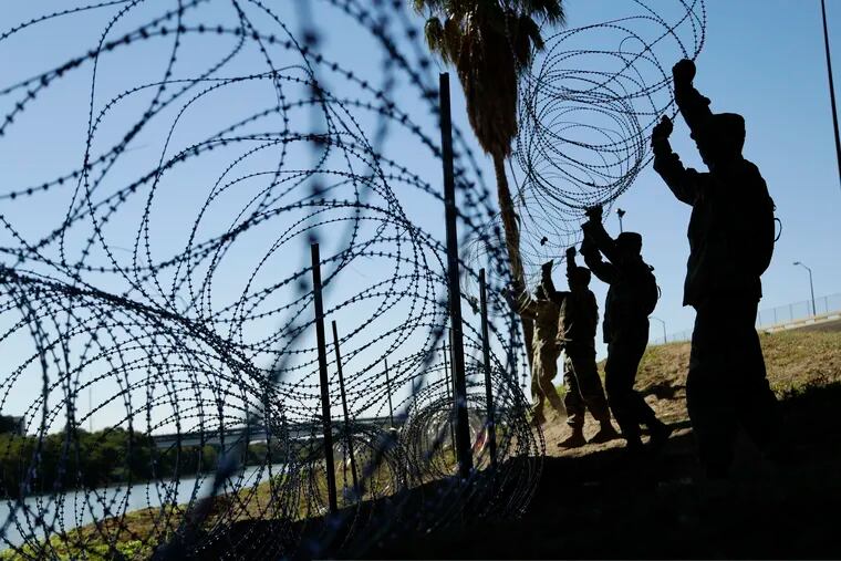 FILE - In this Nov. 16, 2018, file photo, members of the U.S. military install multiple tiers of concertina wire along the banks of the Rio Grande near the Juarez-Lincoln Bridge at the U.S.-Mexico border in Laredo, Texas. Acting Defense Secretary Pat Shanahan says the U.S. will be sending "several thousand" more American troops to the southern border to provide additional support to Homeland Security. He says the troops will mainly be used to install additional wire barriers and provide increased surveillance of the area. (AP Photo/Eric Gay, File)