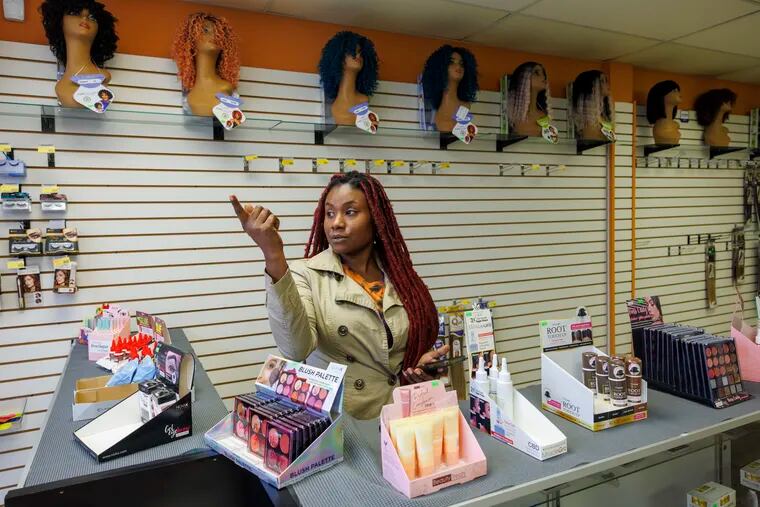 Claudia Silmeas, owner of Nat’s Beauty Supply along Frankford Avenue and Knorr Street was hit by mass theft of merchandise at her small business beauty supply store overnight on Thursday. Behind her is the area targeted by thieves, her most expensive hair.