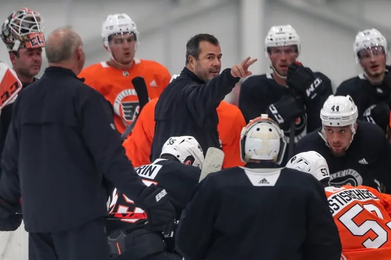 Flyers head coach Alain Vigneault, center, runs practice at the Flyers Skate Zone in Voorhees. The 10th-winningest coach in NHL history, he is a cerebral man who, in his first year with the Flyers, has transformed the team into one of the league’s most surprising stories.