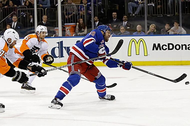 The Rangers' Dominic Moore scores while the Flyers' Hal Gill and Braydon Coburn chase in the second period. (Seth Wenig/AP)
