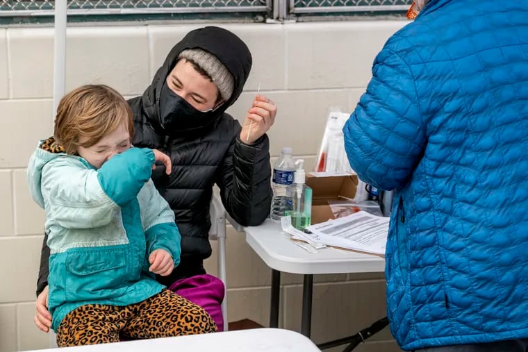 Maggie Harrison, who works as a school nurse, gives her son Max, 6, a nasal swab, at the FEMA-run testing site at Cibotti Recreation Center in Southwest Philadelphia on Sunday. Nurse Arianne Murphy-Flores is at right. The site opened last week and operates daily from 7 a.m. to 5 p.m.
