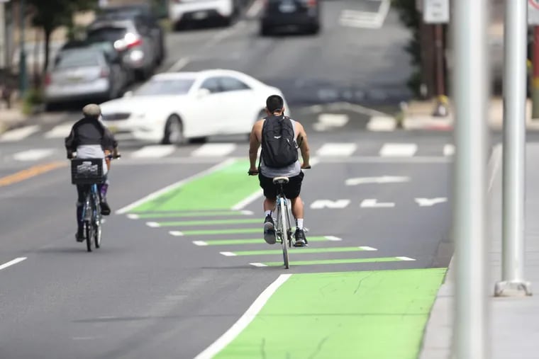 Cyclists use a green bike lane on South Street near 27th Street heading east.