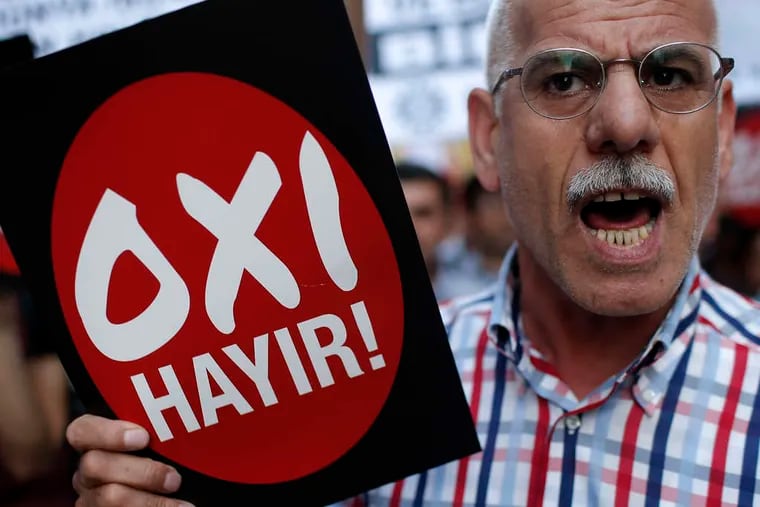 A demonstrator holds a placard with the Greek and Turkish words for &quot;no,&quot; rejecting new austerity measures. Voters will decide the issue Sunday. EMRAH GUREL / AP