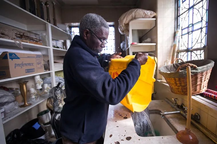 Joseph Mensah empties a mop bucket Saturday, March 28, 2015, at St. Helena's Catholic Church in Olney as the congregation preps for Easter with a spring cleaning. ( DAVID SWANSON / Staff Photographer )