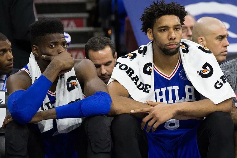 Philadelphia 76ers center Nerlens Noel (left) and center Jahlil Okafor (right) watch from the bench during the final minutes of a game against the Utah Jazz at Wells Fargo Center. The Utah Jazz won 99-71.