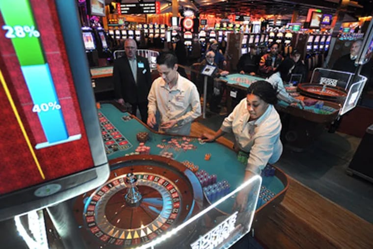 At SugarHouse Casino, Kevin Dang and Shona Beard work the roulette tables. (Sharon Gekoski-Kimmel / Staff Photographer)