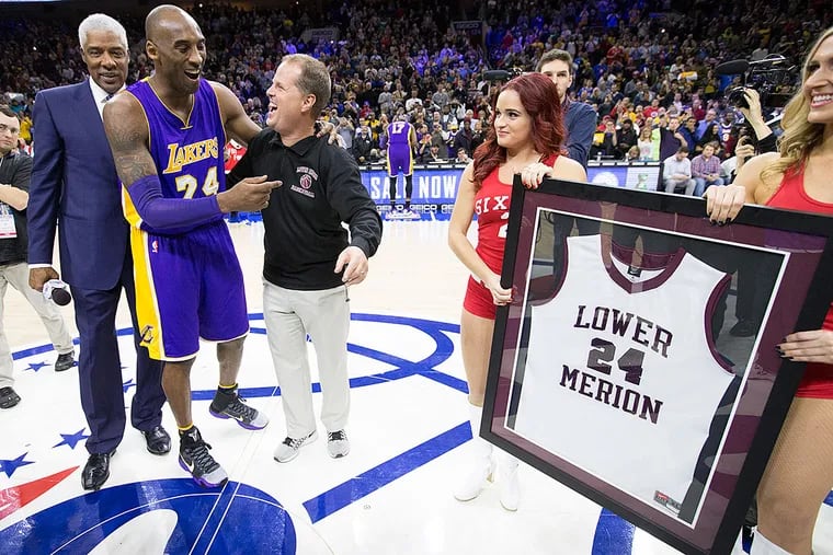 Julius Erving (left) and Lower Merion coach Gregg Downer present Kobe Bryant with a framed Lower Merion jersey.