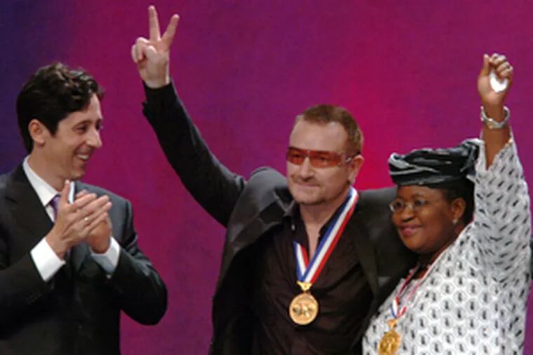 Bono and Ngozi Okonjo-Iweala, who accepted for Bono&#0039;s DATA organization, acknowledge applause from the National Constitution Center&#0039;s Joseph Torsella and the audience after receiving their medals.